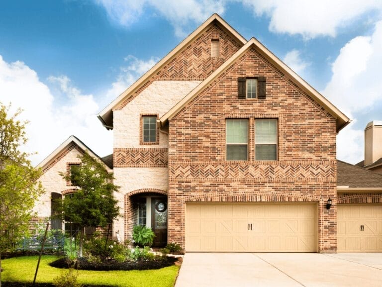 Brick home in the Texas Hill Country with well-maintained landscaping and a three-car garage