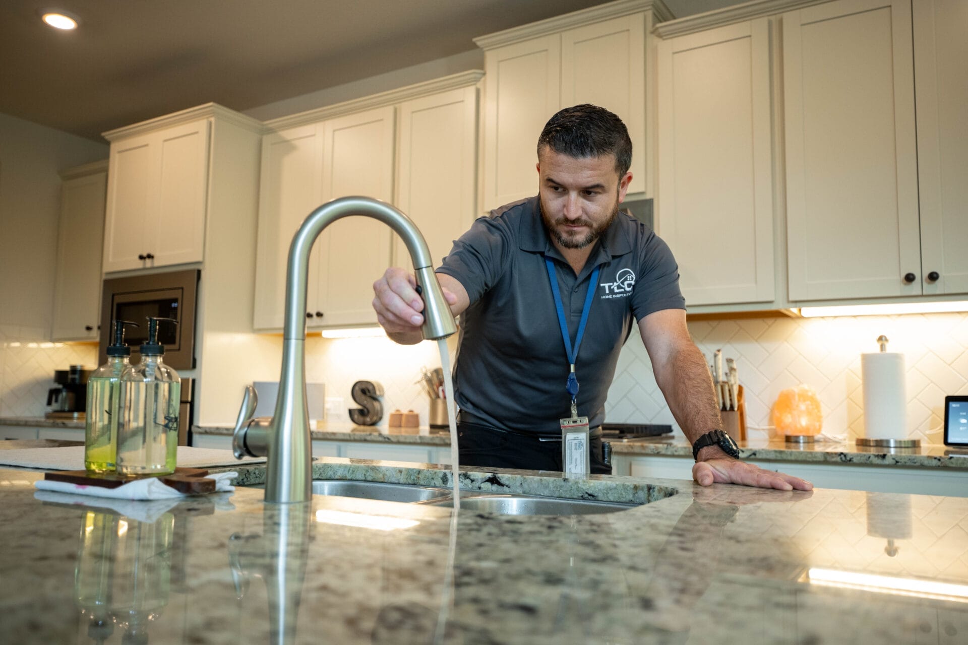 TLC home inspector performing plumbing testing during a home inspection in Austin and San Antonio by running a bathroom sink
